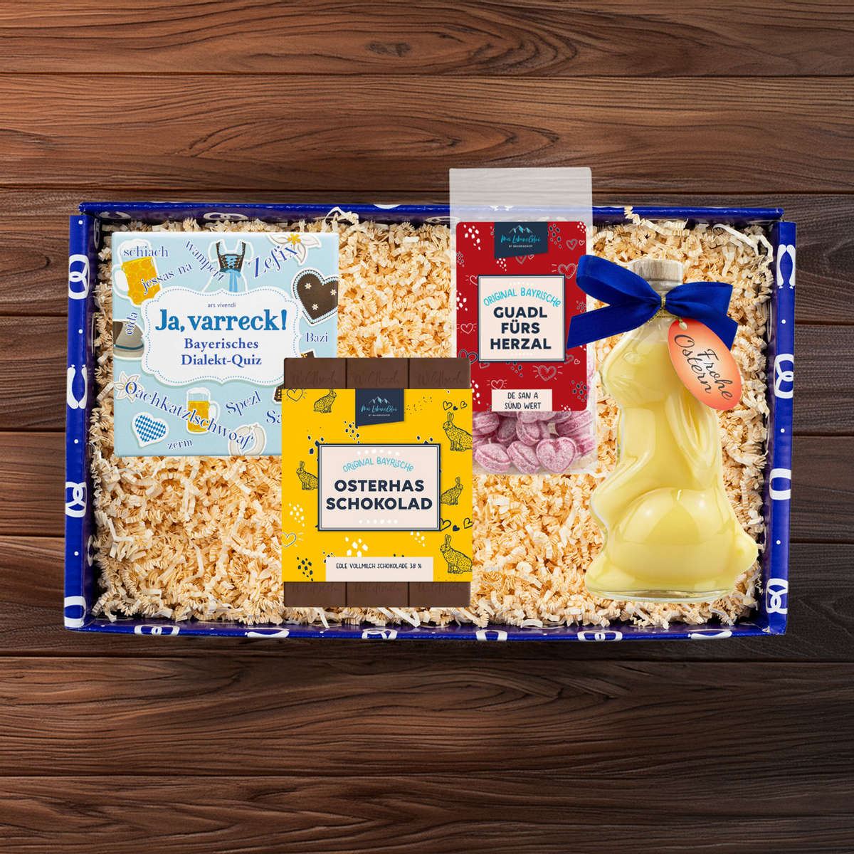 Geschenkbox Ostern für de Großn mit Dialekt-Quiz, Ostereierlikör-Hase, Herzl-Bonbons & Osterhasen-Schokolade.
