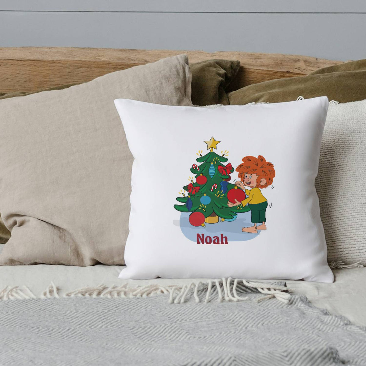 Pumuckl Kuschelkissen Weihnachten, personalisiert mit Namen Noah, zeigt Pumuckl beim Schmücken des Weihnachtsbaumes.