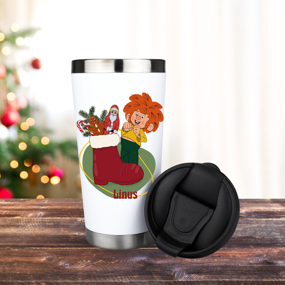 Personalisierbarer ®Pumuckl Thermo-Becher Nikolaus mit buntem Weihnachtsdesign auf Holzoberfläche und Tannenbaum.