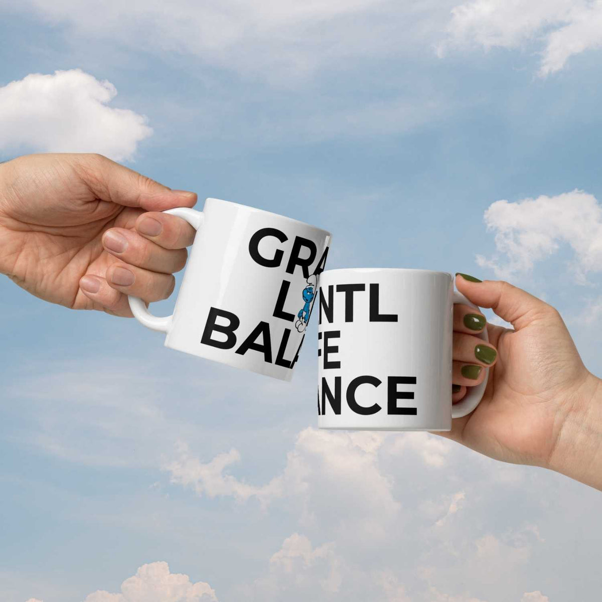 Zwei Personen stoßen mit weißen Schlümpfe Tassen Grantl life balance vor blauem Himmel an.