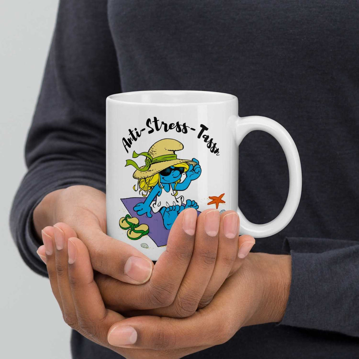 Weiße Schlümpfe Tasse Anti Stress Damen mit Schlumpfine am Strand, in Händen gehalten.