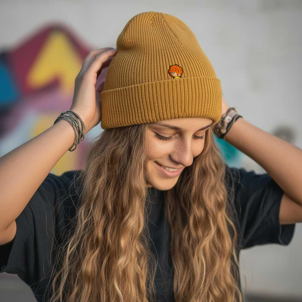 Junge Frau trägt eine gelbe Baumwoll-Pumuckl Beanie mit gesticktem Logo, lächelnd und glücklich.