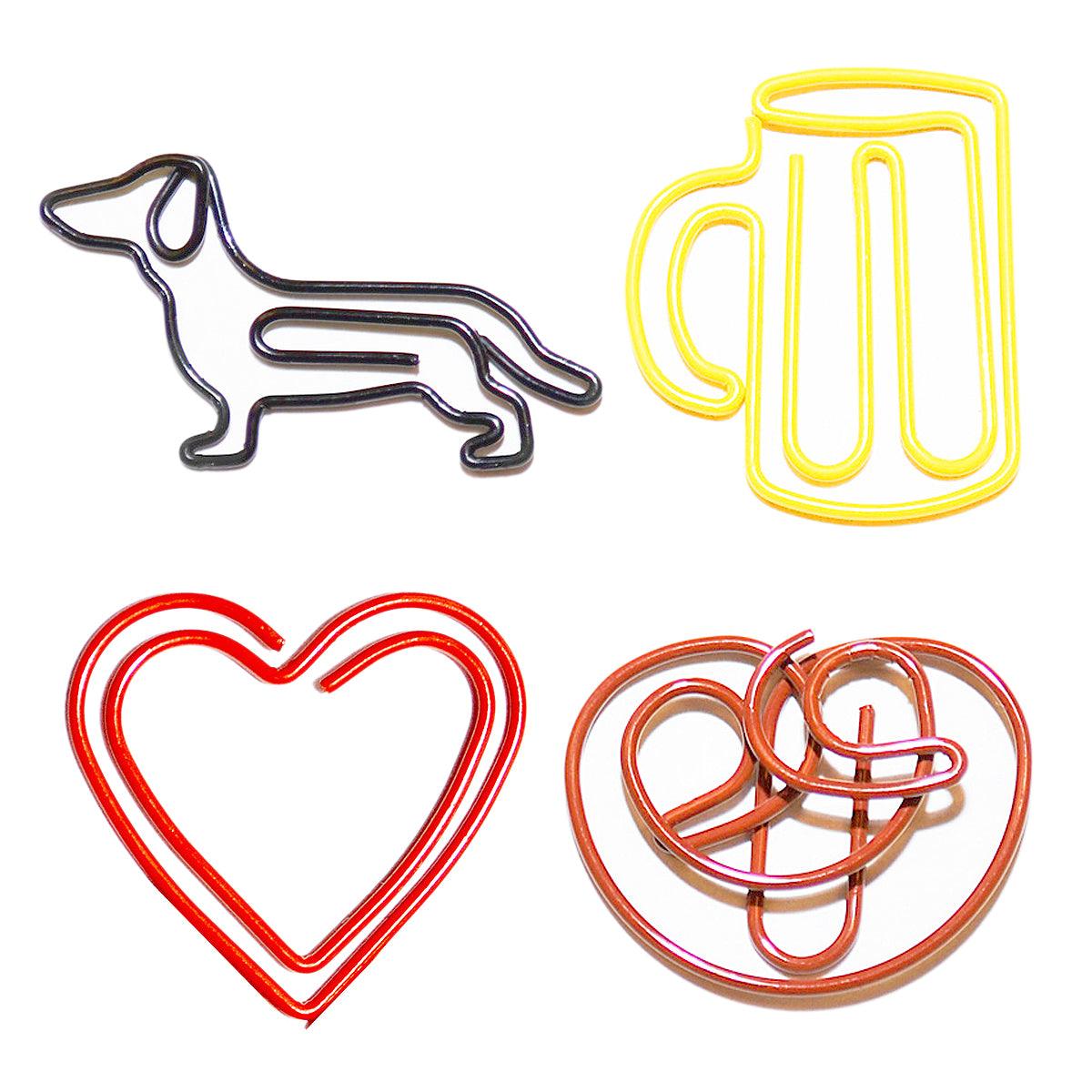 Vier bunte Büroklammern in besonderen Formen: Dachshund, Bierkrug, Herz und Brezel für personalisierte Akzente.