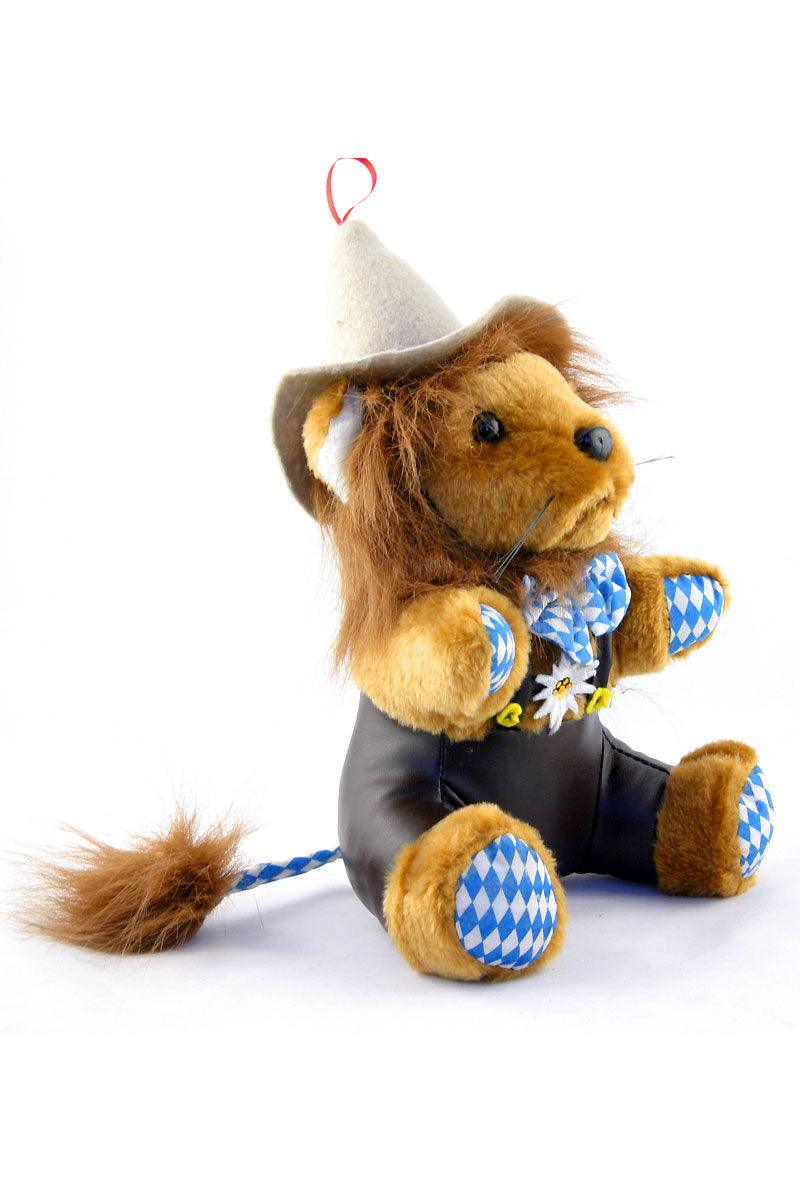 Sitzender, brauner Plüsch-Löwe in bayerischer Lederhose mit Hut, blau-weißem Karomuster am Hals und Edelweiß.