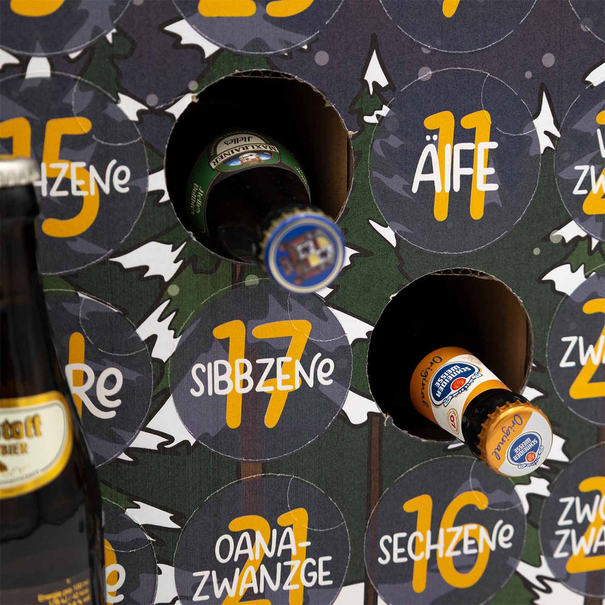 Nahaufnahme des Bayerischen Bier Adventskalenders "Märchenwald" mit geöffneten Türchen und sichtbaren Bierflaschen.