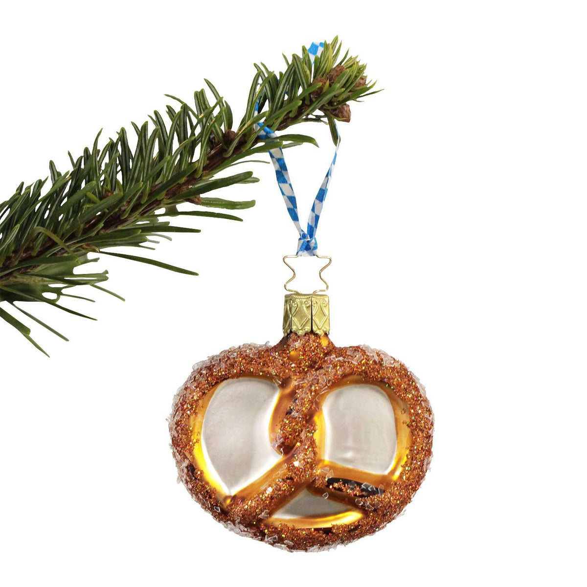 Glitzernde Brezel Weihnachtsbaumkugel in "Bescherung" Geschenkbox hängend am Tannenzweig mit blauem Band.