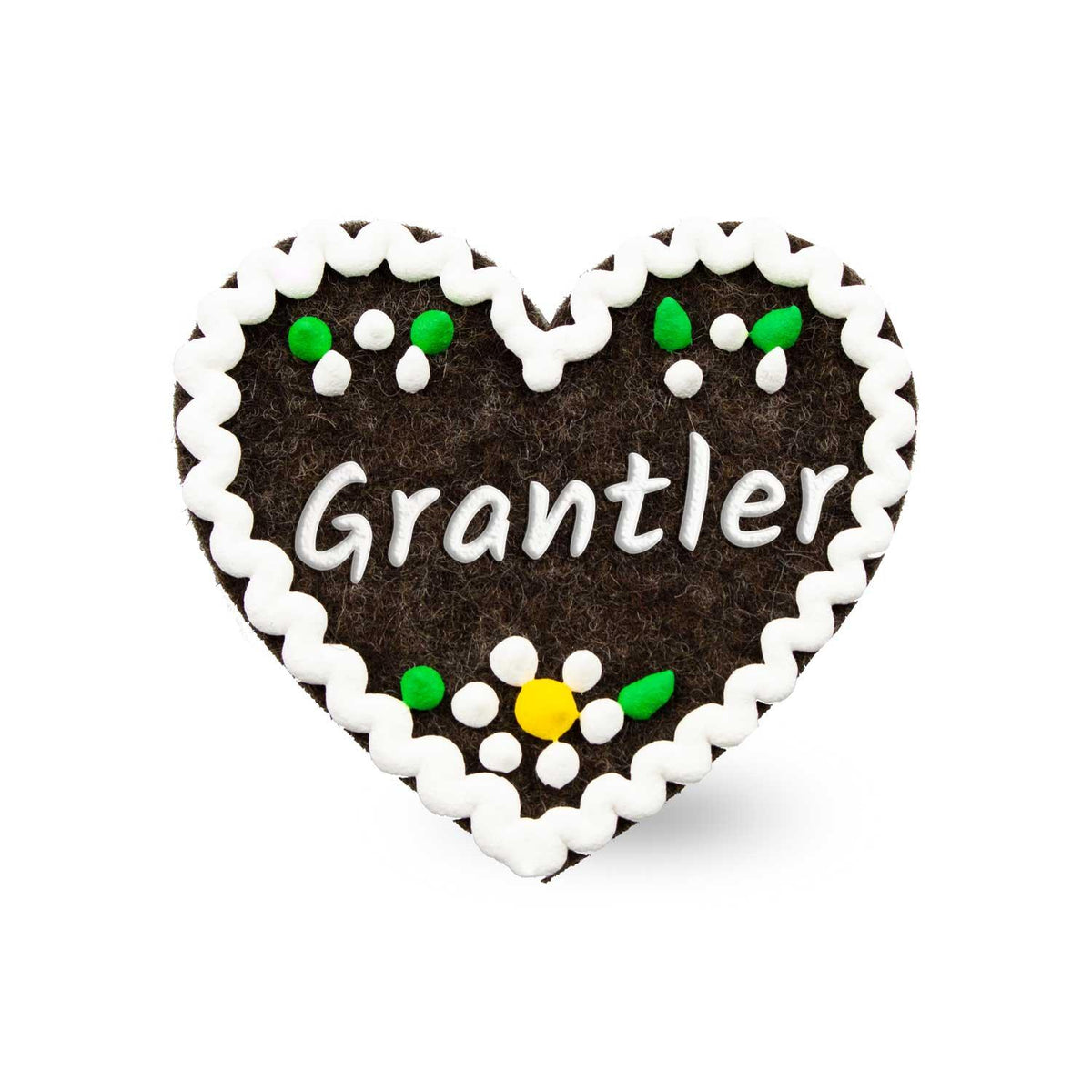 Brauner Filzherz-Anstecker "Grantler" mit weißer Verzierung, grünen Blättern und gelber Blüte.