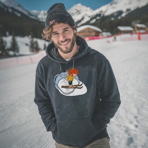 Mann im dunkelblauen Pumuckl Hoodie „Skifahren“ beim Skifahren in den Bergen