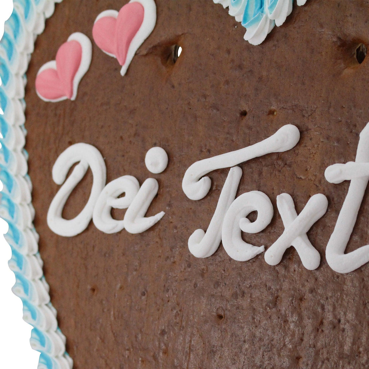 Braunes Lebkuchenherz mit weißer Zuckerguss-Aufschrift, blauer und rosa Dekoration, ideal als Geschenk.