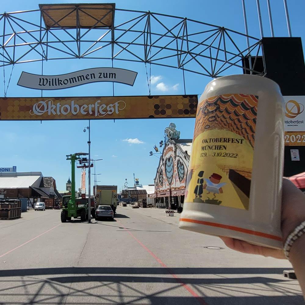 Offizieller Oktoberfestkrug 2022 mit detailliertem Motiv vor dem Eingang zum Münchner Oktoberfest.