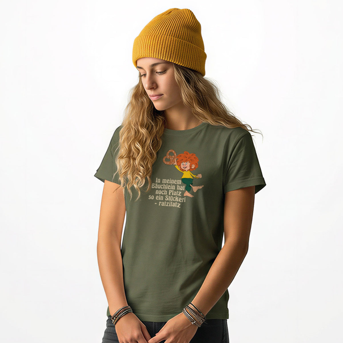 Frau im olivgrünen Pumuckl T-Shirt Damen „Brezn Stückerl“ mit gelber Mütze