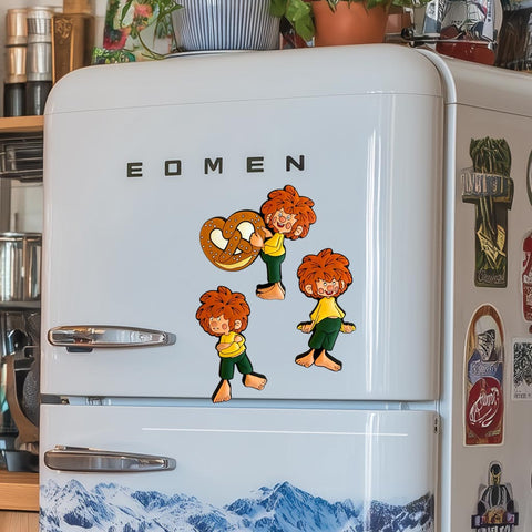 Pumuckl Kühlschrankmagnet Set: drei Pumuckl Magnete am weißen Kühlschrank, einer hält eine Brezel