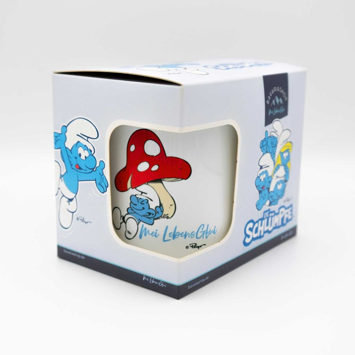 ®Die Schlümpfe Emailletasse "Do legst di nieda" in Geschenkbox mit Schlumpfmotiv und Pilzillustration.