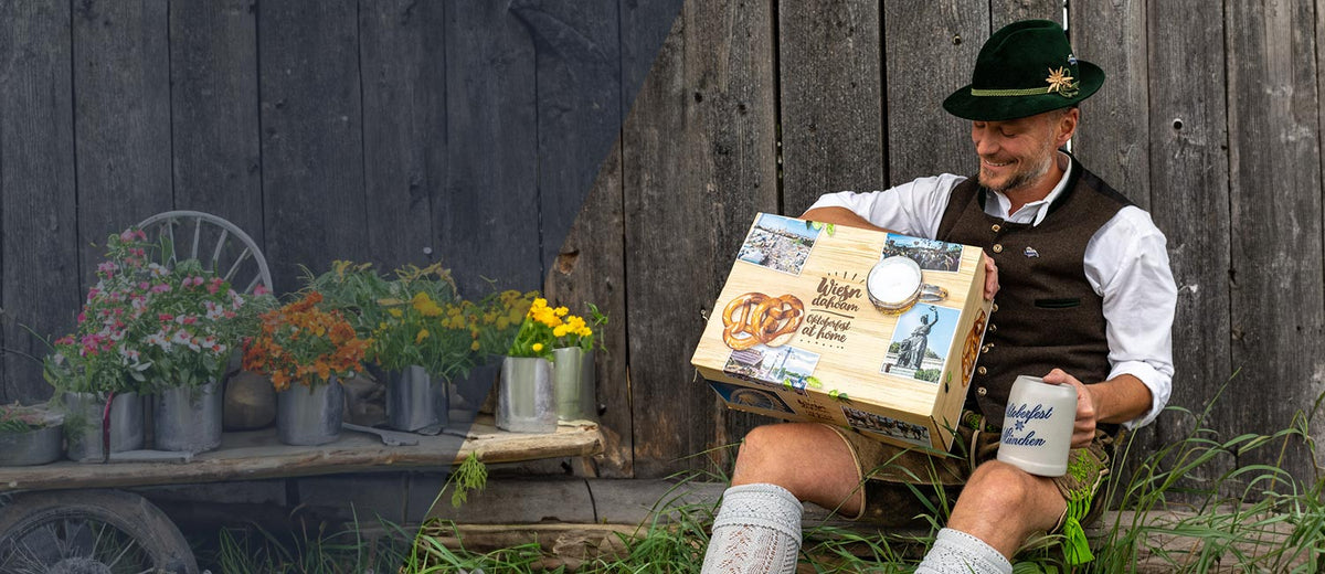 Mann in Tracht mit Wiesn Geschenkbox und Bierkrug, Oktoberfest & Wiesn Dahoam Kollektion.