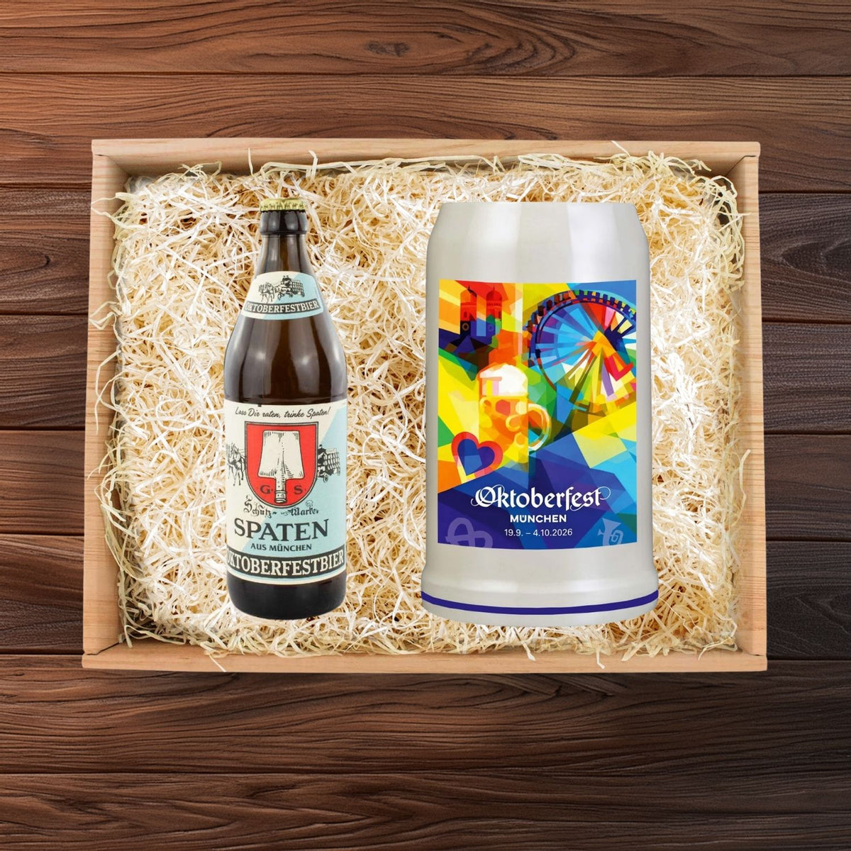 Oktoberfest-Geschenkbox mit Spaten Festbier und weißem Bierkrug mit farbigem Oktoberfest-Design, verpackt in Holzwolle.