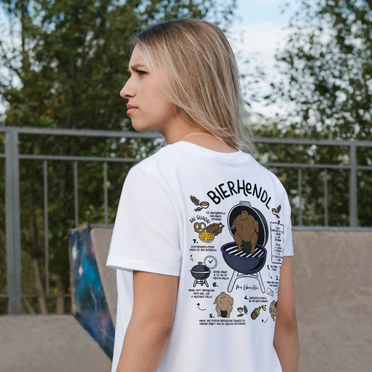 Junges Model präsentiert weißes Damen Rezept T-Shirt Bierhendl mit detailliertem Bierhähnchen-Grillrezept auf dem Rücken.