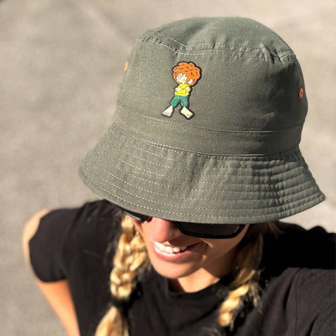 Frau trägt den olivgrünen Pumuckl Fischerhut Grantla mit aufgenähtem Pumuckl-Weblabel – Bucket Hat unisex