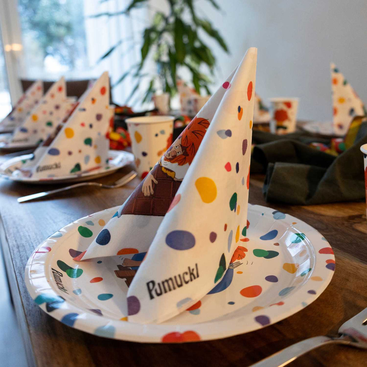 Geburtstagstafel mit Pumuckl Partygeschirr: Pappteller mit Pumuckl-Schriftzug, gefaltete Servietten und Becher für mehrere Kinder
