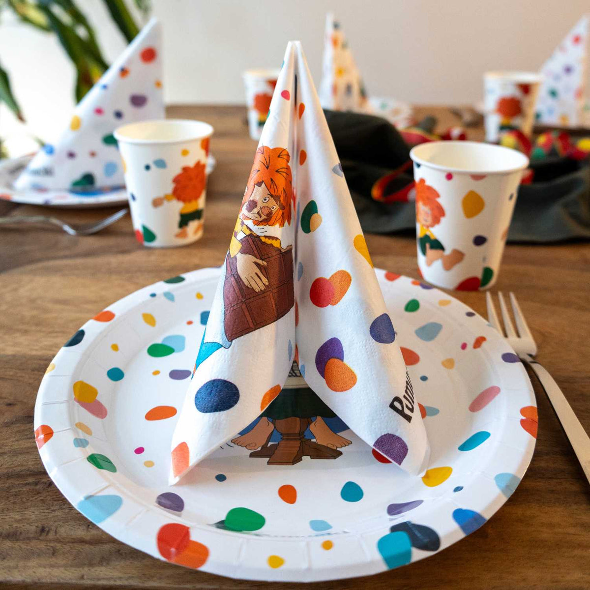 Gedeckter Kindergeburtstag-Tisch mit Pumuckl Pappteller, aufgestellt gefalteter Pumuckl Serviette und Pappbechern