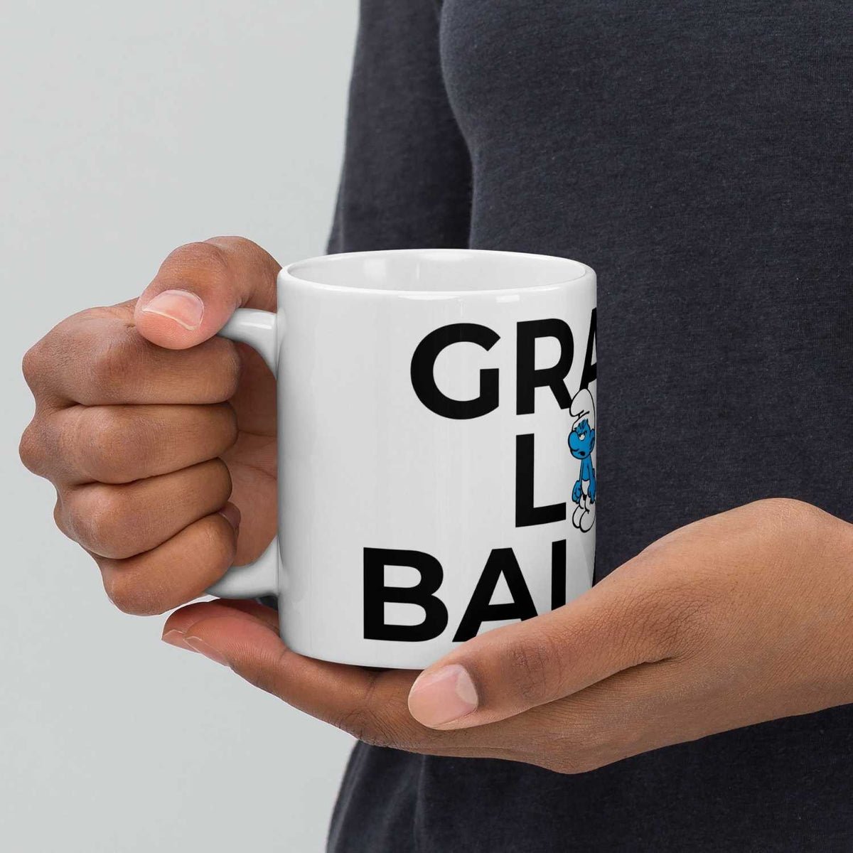 Weiße Schlümpfe Tasse Grantl life balance mit Grantelbart Comic Figur und großem Schriftzug, gehalten von einer Hand.
