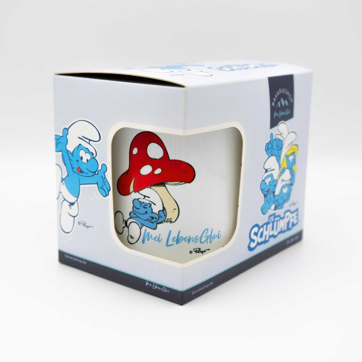 Die Schlümpfe Tasse "Do legst di nieda" in Geschenkverpackung mit Pilz und Schlumpf-Motiv.