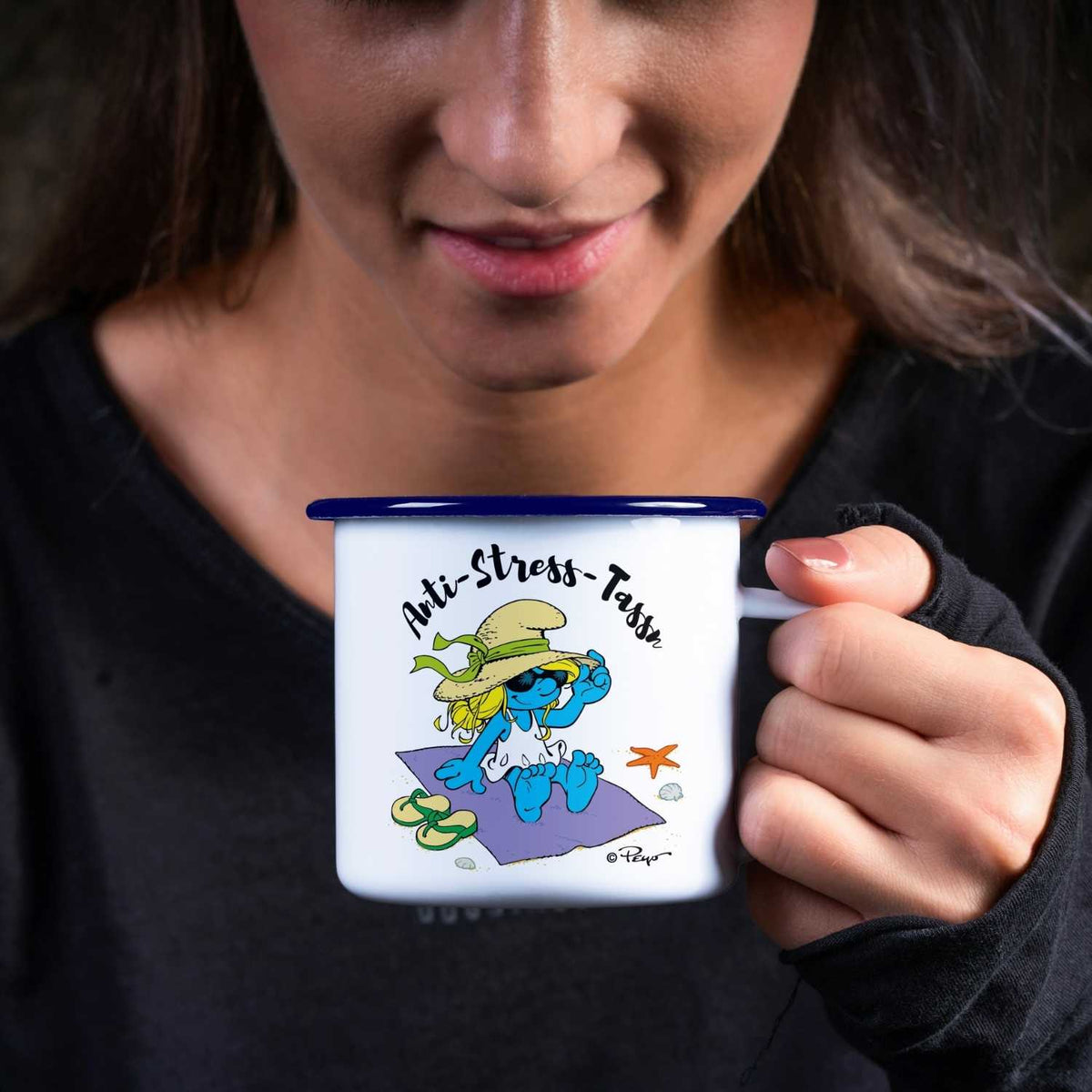 Frau hält blaue und weiße Schlümpfe Emailletasse Anti Stress Damen mit Strandschlumpf-Motiv.