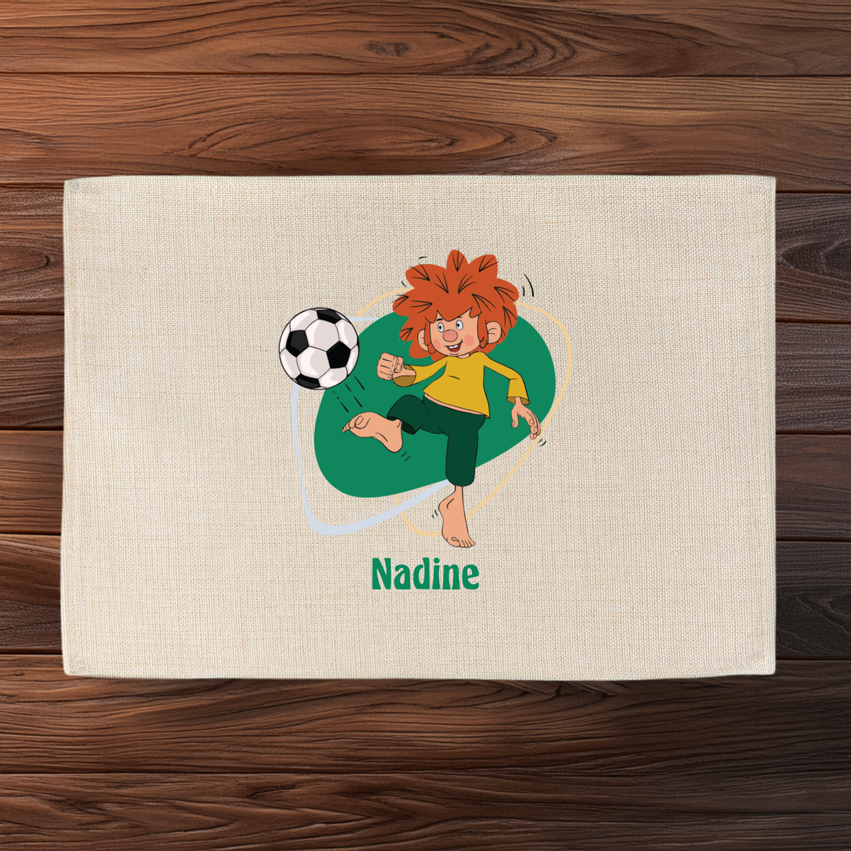 Pumuckl Tischset mit Fußballmotiv und individuellem Namen Nadine, beiges Textil auf Holztisch