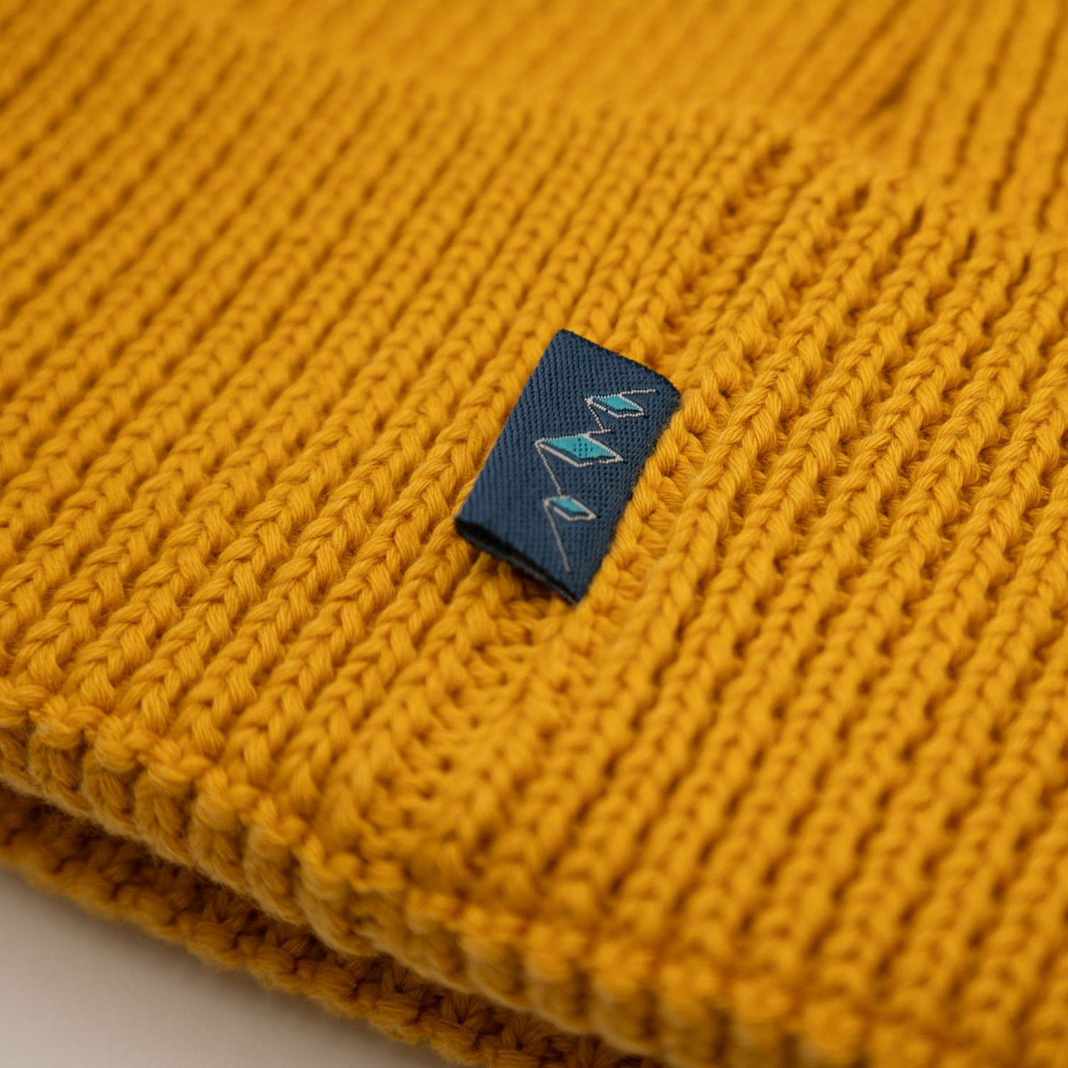 ®Pumuckl Beanie aus Baumwolle in leuchtendem Gelb, gestrickte Struktur und kleines Logo-Etikett.