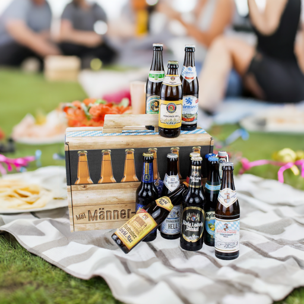 Männer-Handtasche mit bayerischen Bierflaschen auf einer Picknickdecke im Grünen