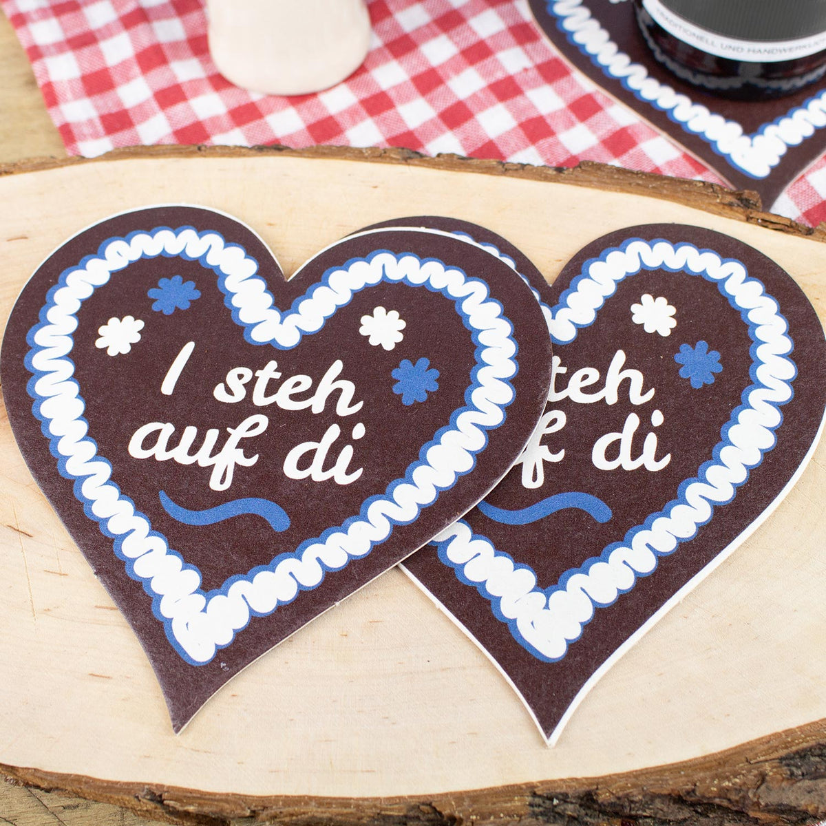 Zwei Bierfuizl-Lebkuchen-Herzen I steh auf di auf Holzbrett mit bayerischem Vichy-Karo im Hintergrund.