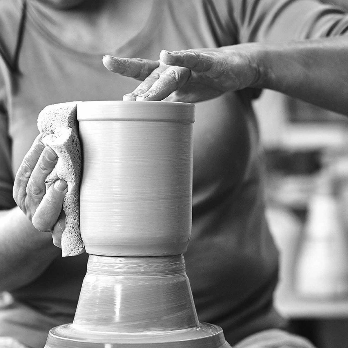 Hände formen einen Tonkrug auf einer Töpferscheibe, Handwerkskunst und traditionelle Fertigung.