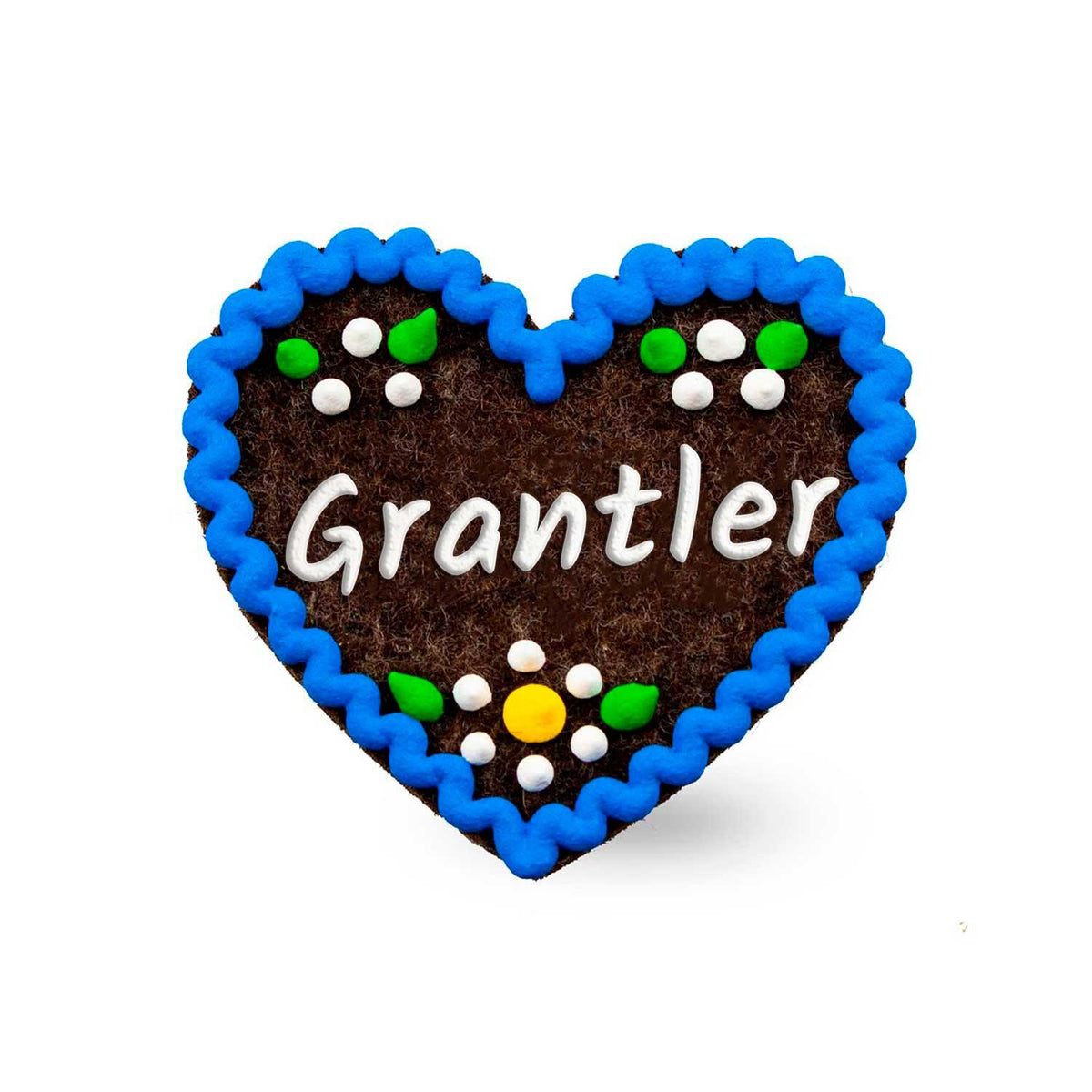 Brauner Filzherz-Anstecker "Grantler" mit blauem Zackenrand und weißen, grünen sowie gelben Verzierungen.