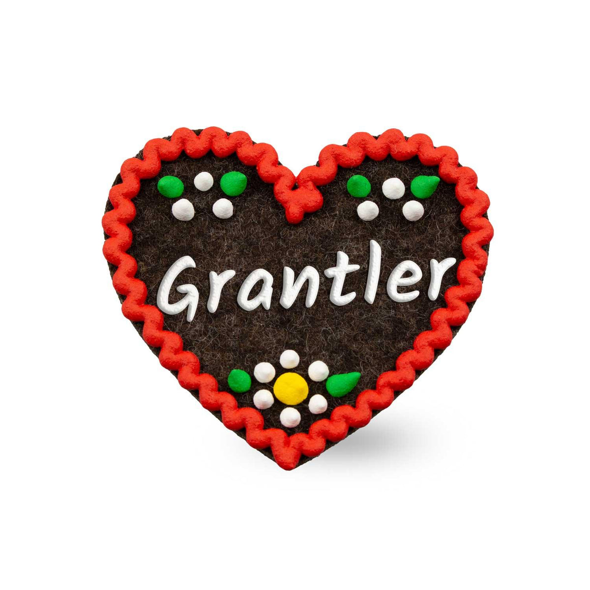 Brauner Filzherz-Anstecker "Grantler" mit rotem Zickzackrand, weißer Schrift und bunten floralen Details.
