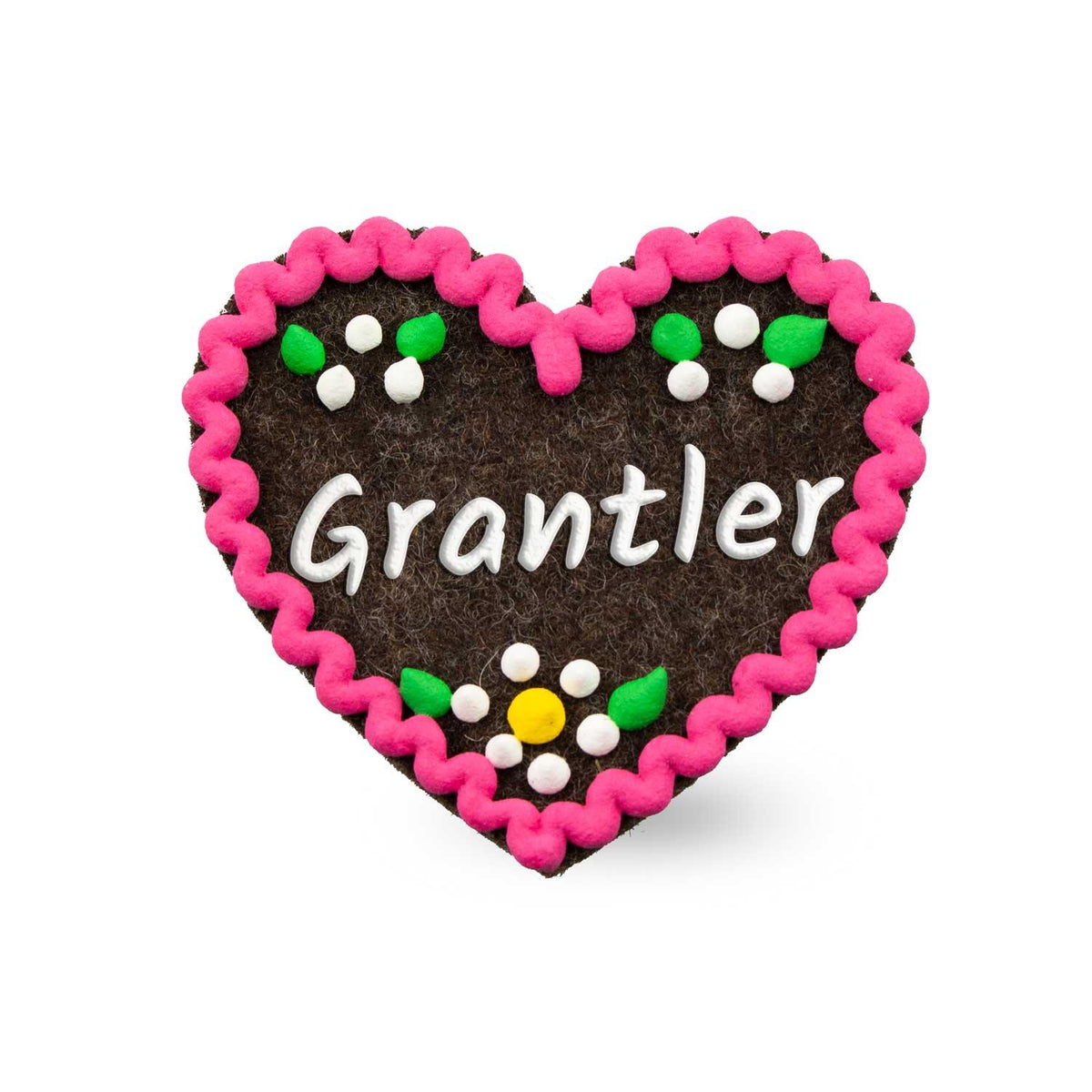 Brauner Filzherz-Anstecker Grantler mit pinker Zackenkante und bunten Filzblumen darauf.