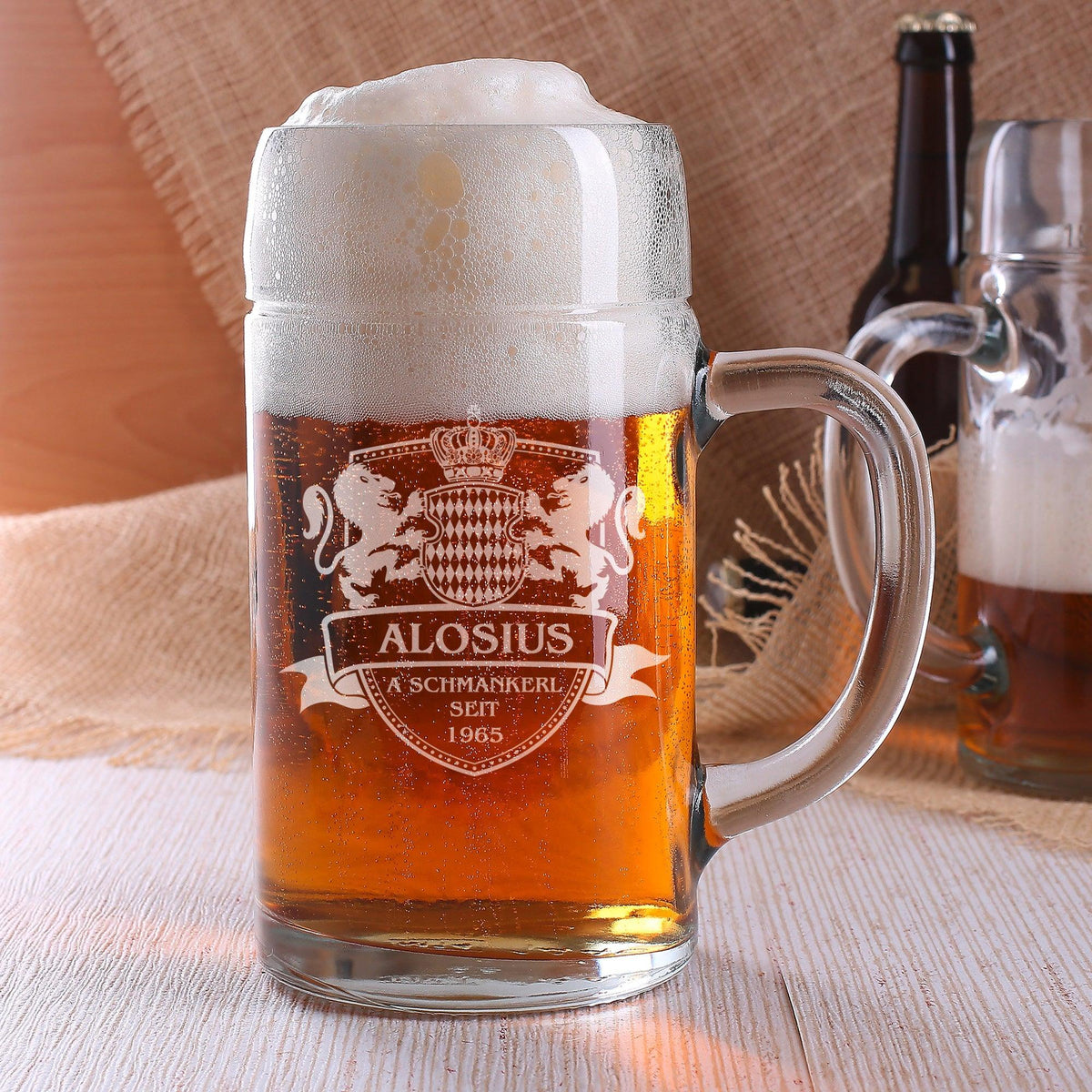 Personalisierter Bierkrug mit eingraviertem Wappen, Name Aloisius und Jahreszahl 1965, gefüllt mit Schaumbier.