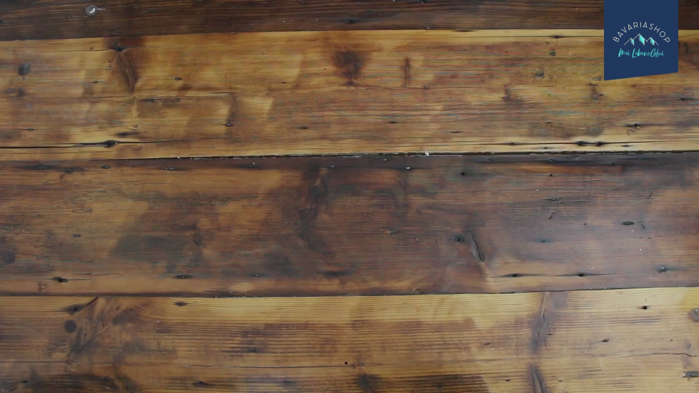 Rustikale Holzwand mit dunklen Brandspuren und Gebrauchsspuren, ideal für eine authentische Shop-Video-Vorschau.