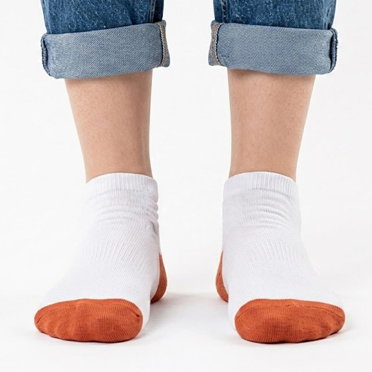 Weiße Pumuckl Sneaker Socken von vorne mit orangefarbener Spitze, getragen mit hochgekrempelter Jeans