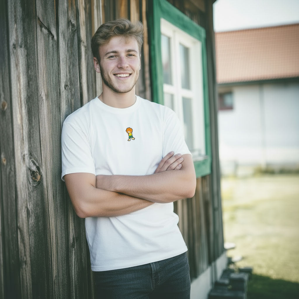 Mann im weißen Pumuckl Grantler Shirt „Grantla“ an einer Holzwand – gewebtes Pumuckl-Label auf der Brust