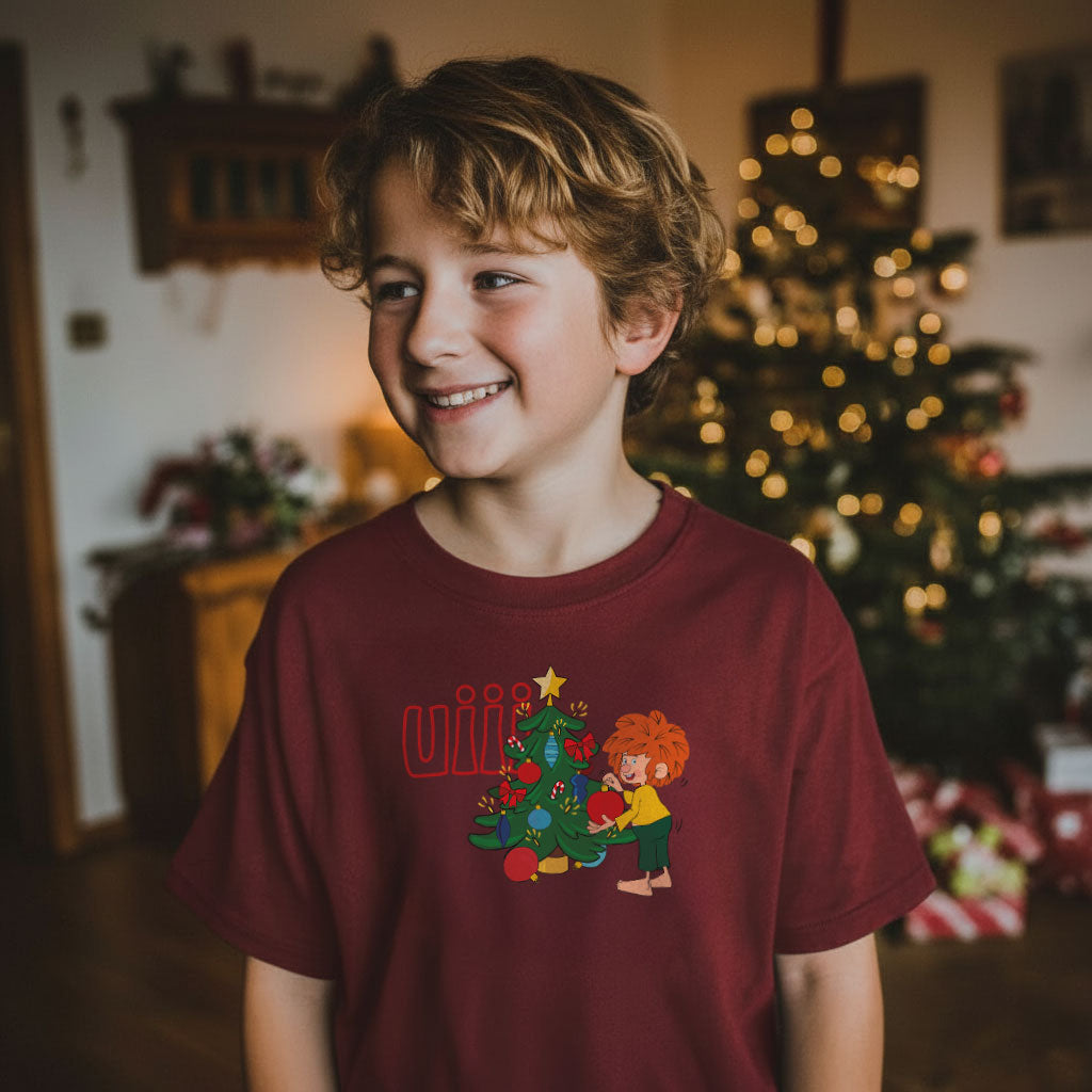Junge im Pumuckl T-Shirt für Kinder mit Weihnachtsmotiv „uiii“ vor geschmücktem Christbaum