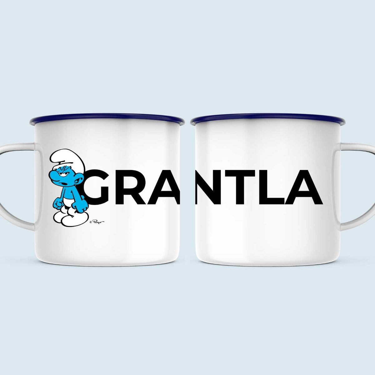 Die Schlümpfe Emailletasse Grantla mit brummigem Schlumpf-Motiv und Schriftzug auf weißem Grund.