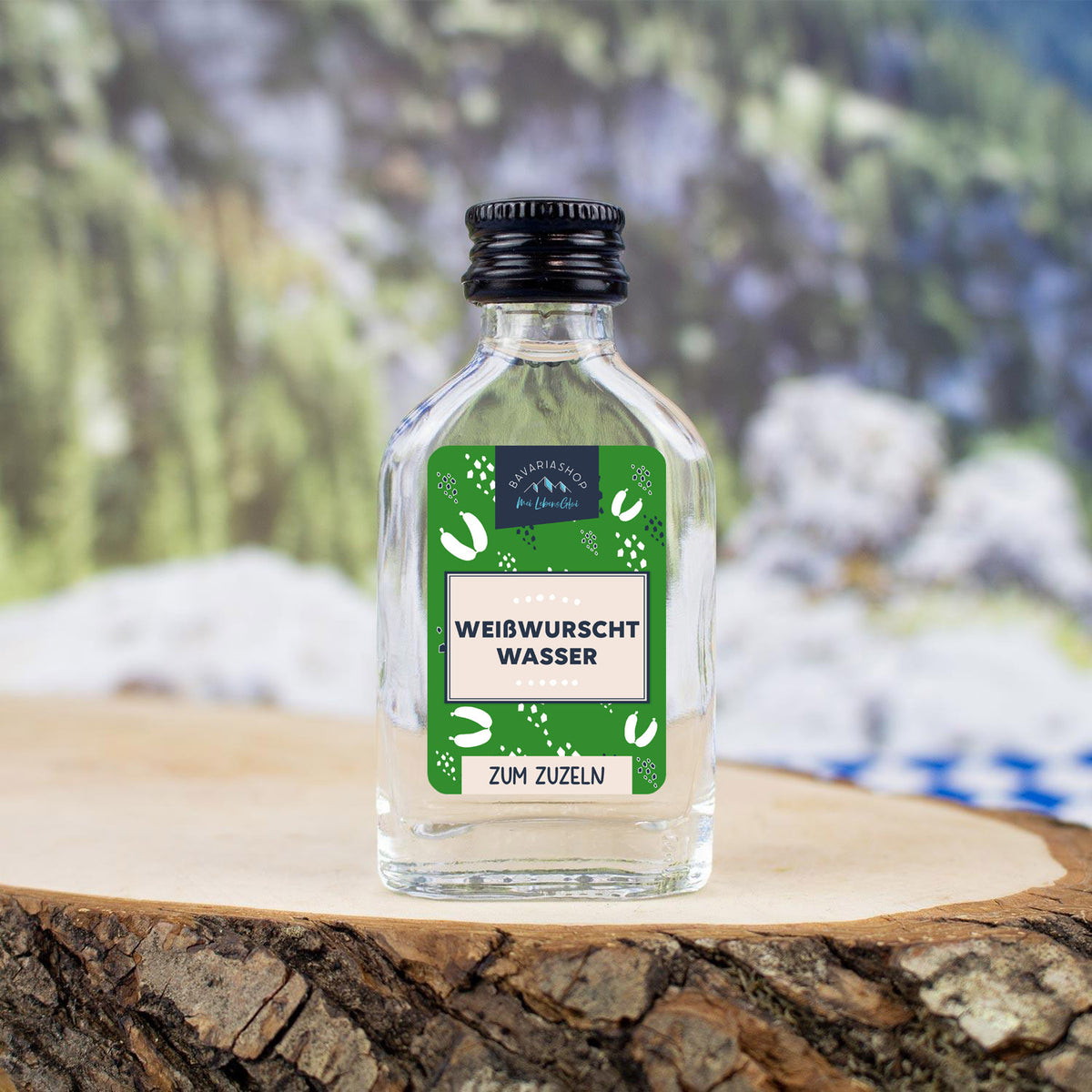 Klarer Obstler in transparenter Mini-Glasflasche mit bayrischem Etikett und Aufdruck „Weißwurschtwasser“, 2 cl.