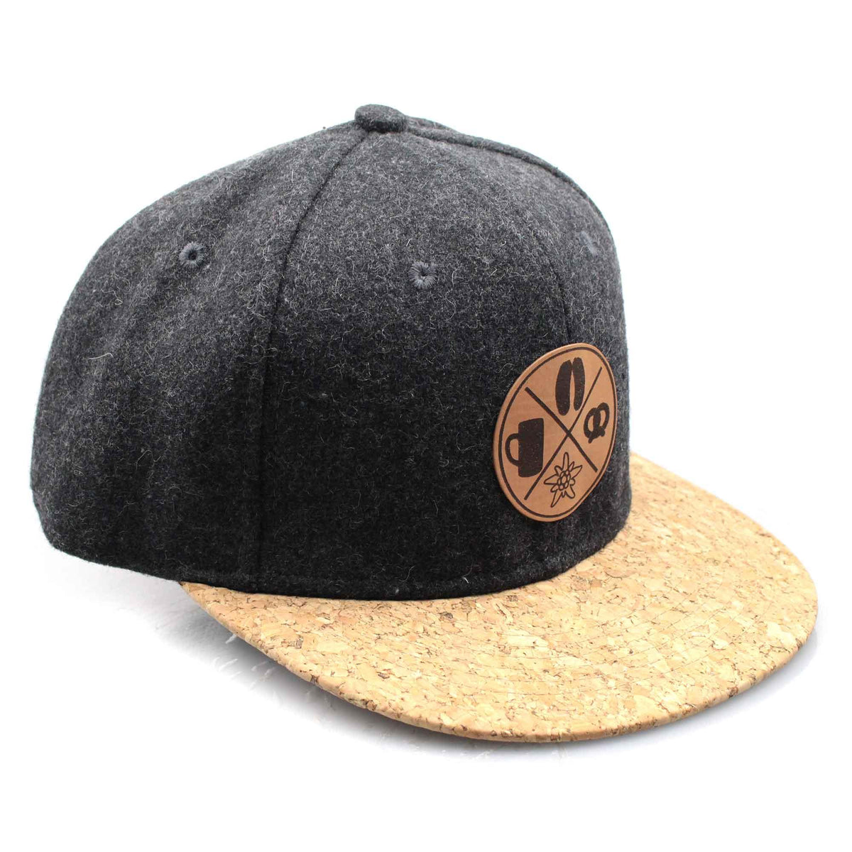 Dunkelgraue Snapback Cap aus Filz mit Kork-Visier und bayerischem Leder-Patch mit Edelweiß, Krug und Brezel-Motiven.